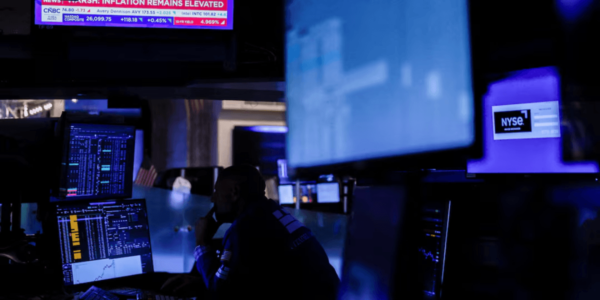 Trader monitoring stock market data amid blue-lit screens in a trading room