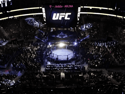 Aerial view of a packed UFC event at T-Mobile Arena with an illuminated octagon